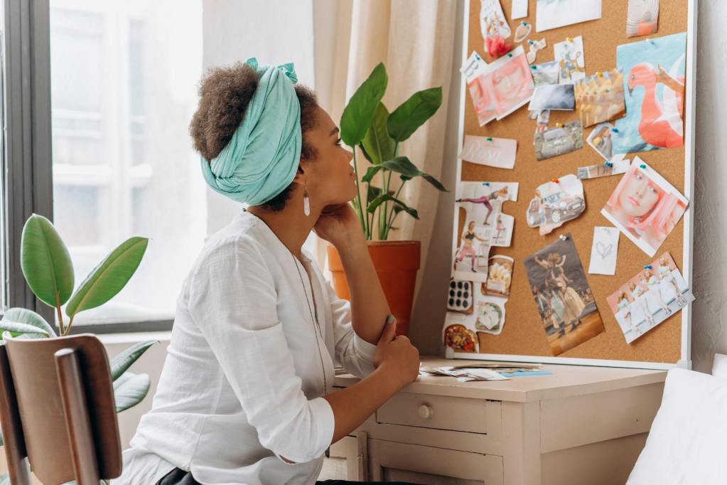 woman in white top looking at corkboard